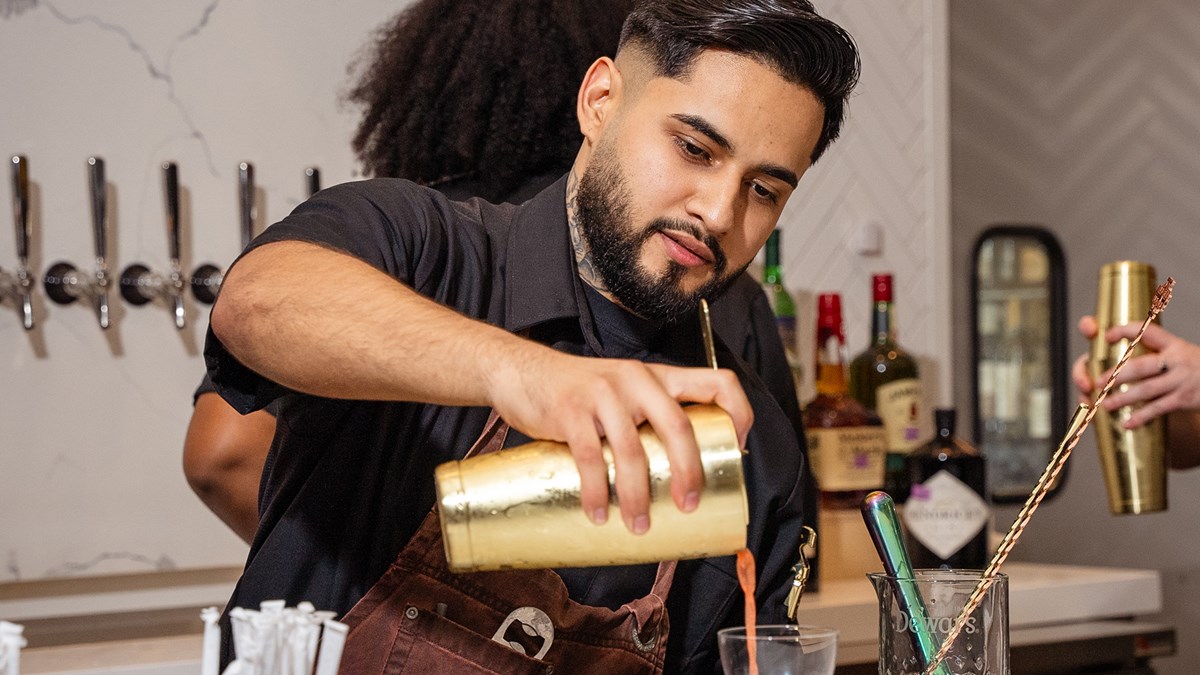 Team member pouring a cocktail